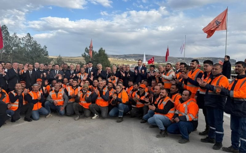 Musabeyli Ayrım–Kilis yolu açılışında turuncu iş kıyafetli şantiye ekibi ve protokol üyeleri toplu hâlde