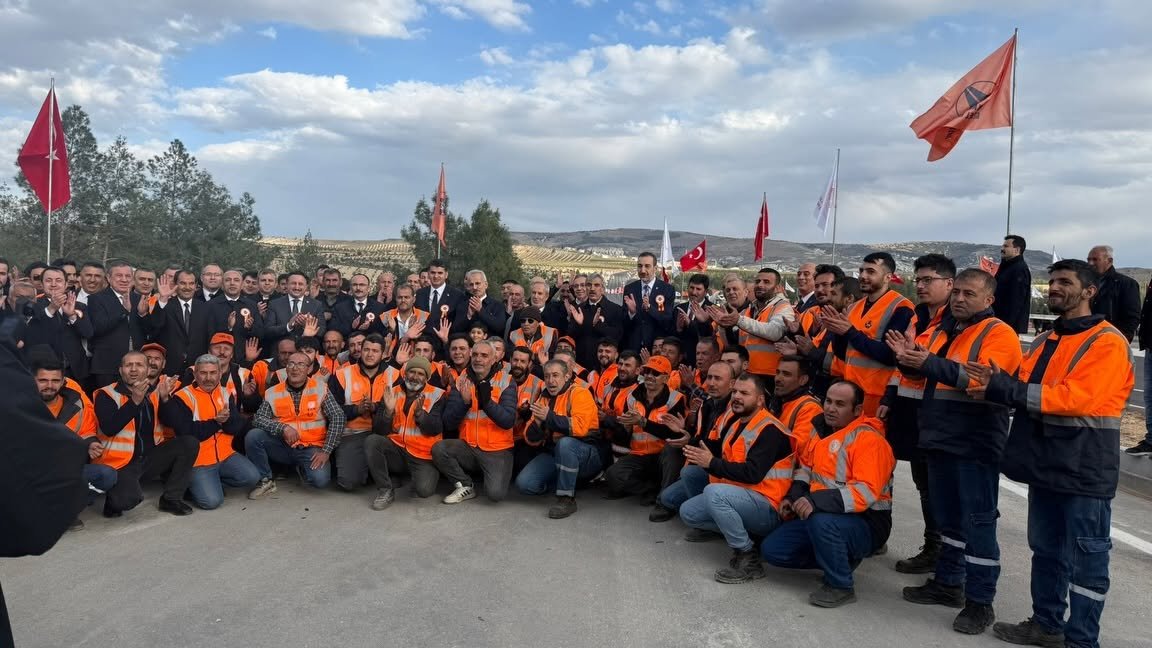 Musabeyli Ayrım–Kilis yolu açılışında turuncu iş kıyafetli şantiye ekibi ve protokol üyeleri toplu hâlde